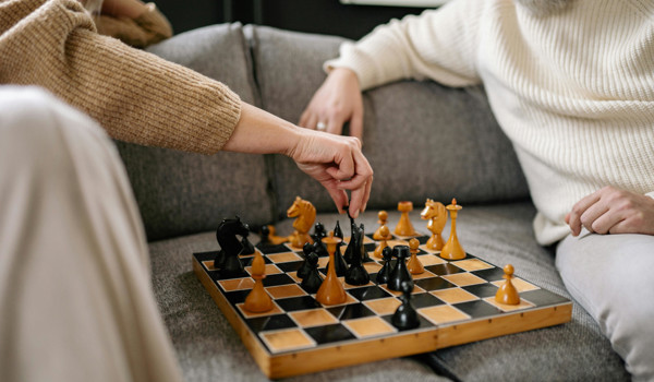 Two Older People Playing Chess Together