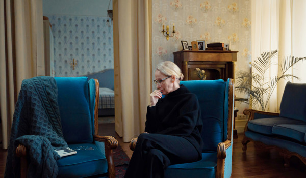Older Woman Sitting In Chair On Her Own