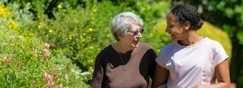 Older Woman And Member Of Staff Waking Together In Street 1