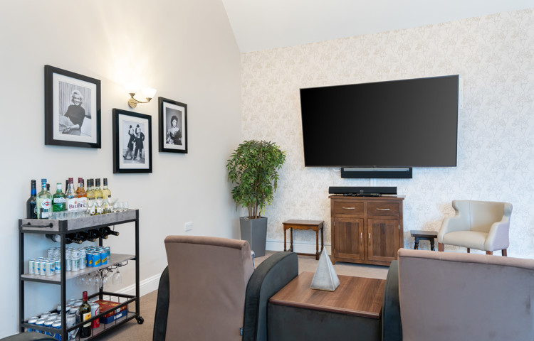 Large television, comfortable armchairs, and a well-stocked drinks trolley at Westall House Residential Care Home in Horsted Keynes.