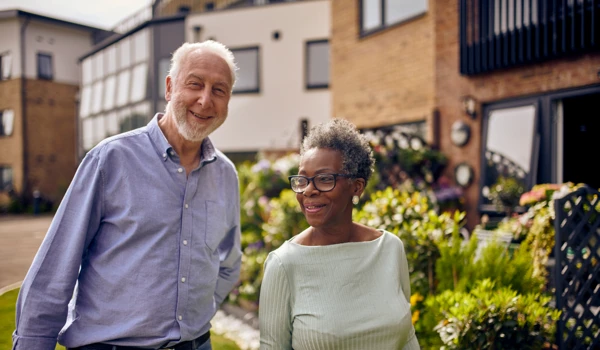 Older Man And Woman Walking Together In Garden
