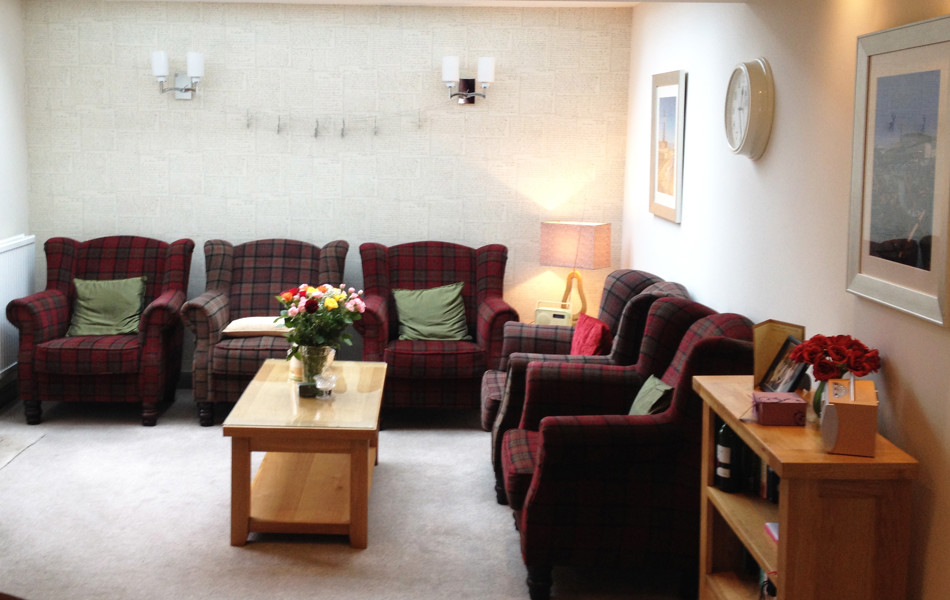 Lounge area with armchairs and flower arrangements on the tables