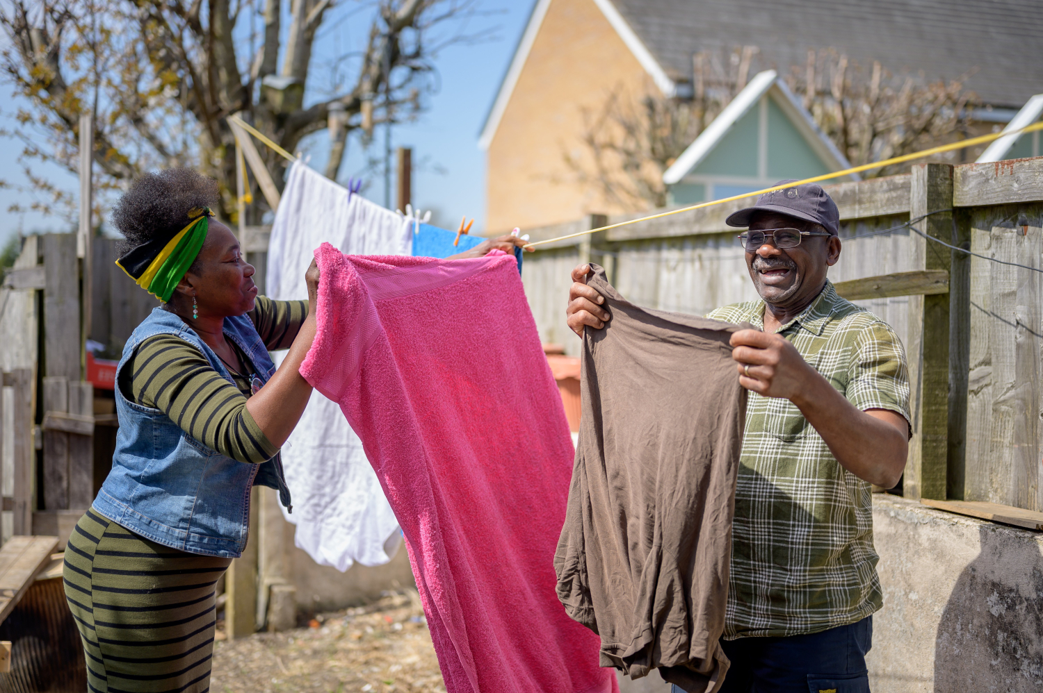 Woman Helping Older Man Put The Washing Out On The Washing Line