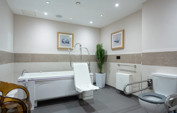 Accessible bathroom at Westall House in Horsted Keynes, featuring a specialised bathtub and support bars