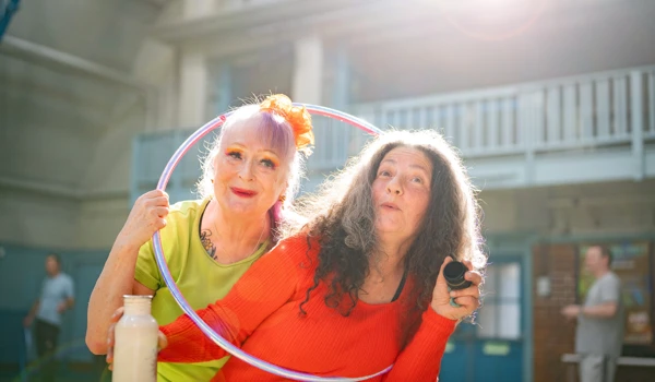 Two Older Women Standing In A Hoop Together