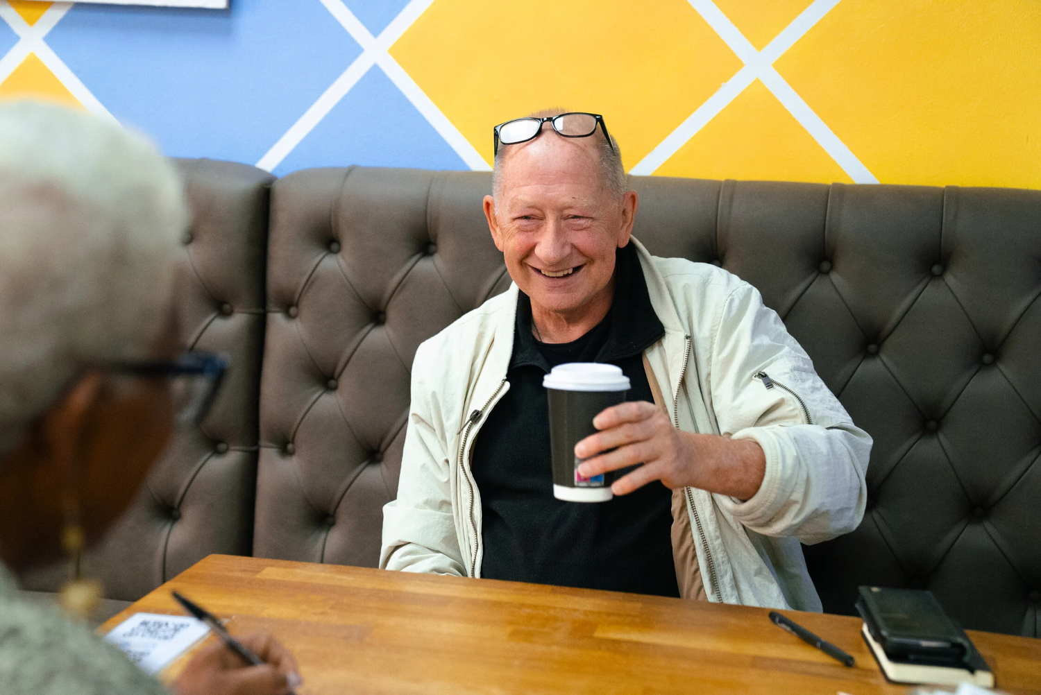 Smiling Older Man Enjoying A Coffee With His Friend