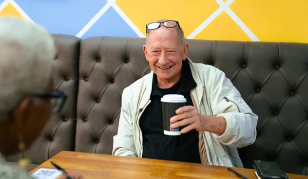 Smiling Older Man Enjoying A Coffee With His Friend