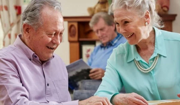 Older Man And Woman Playing A Game At The Table Together