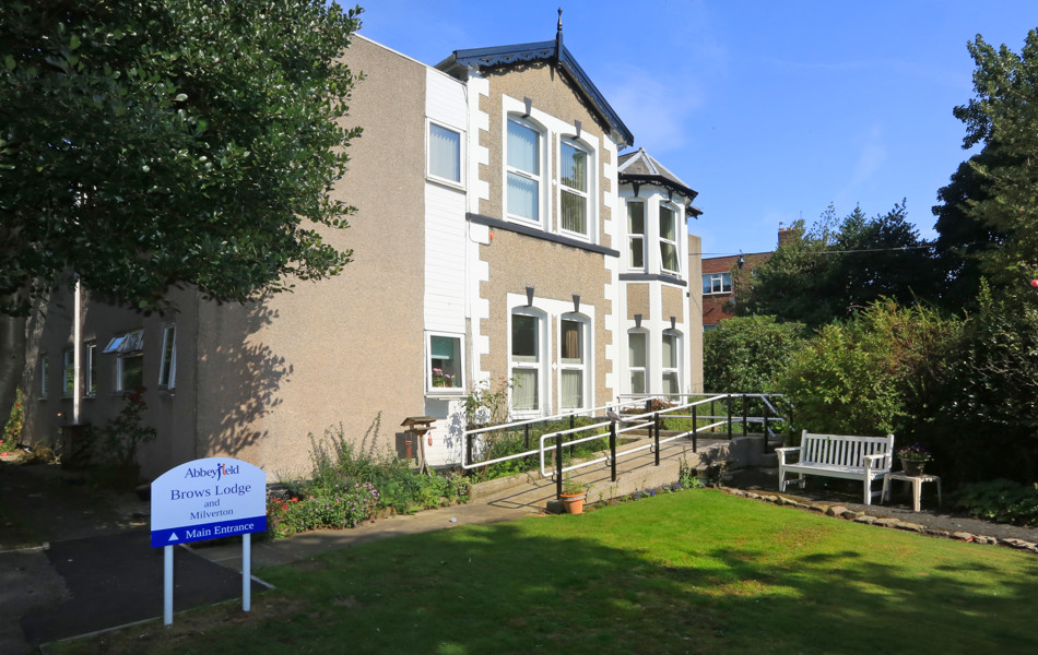 The front of the house with a white bench outside