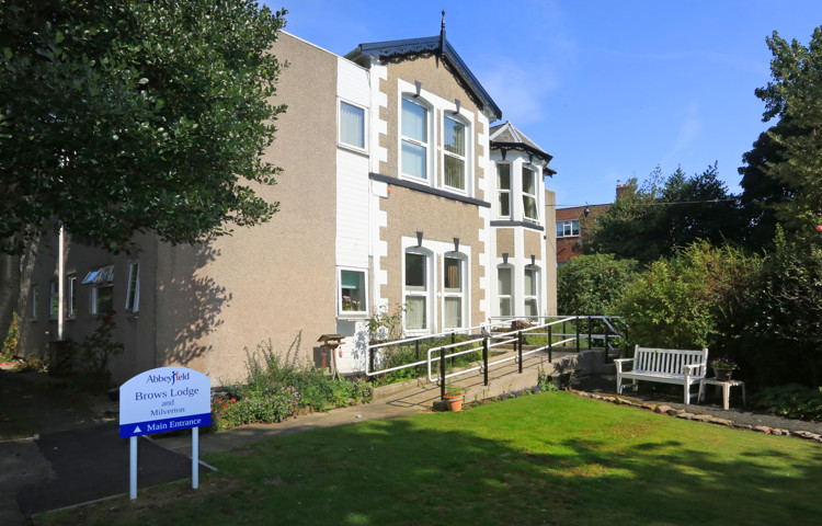The front of the house with a white bench outside