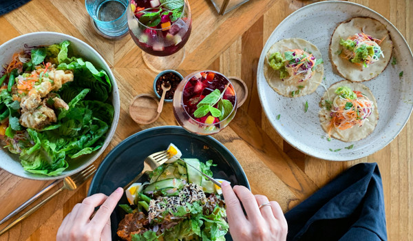People Tucking Into Some Health Meals On Wooden Table