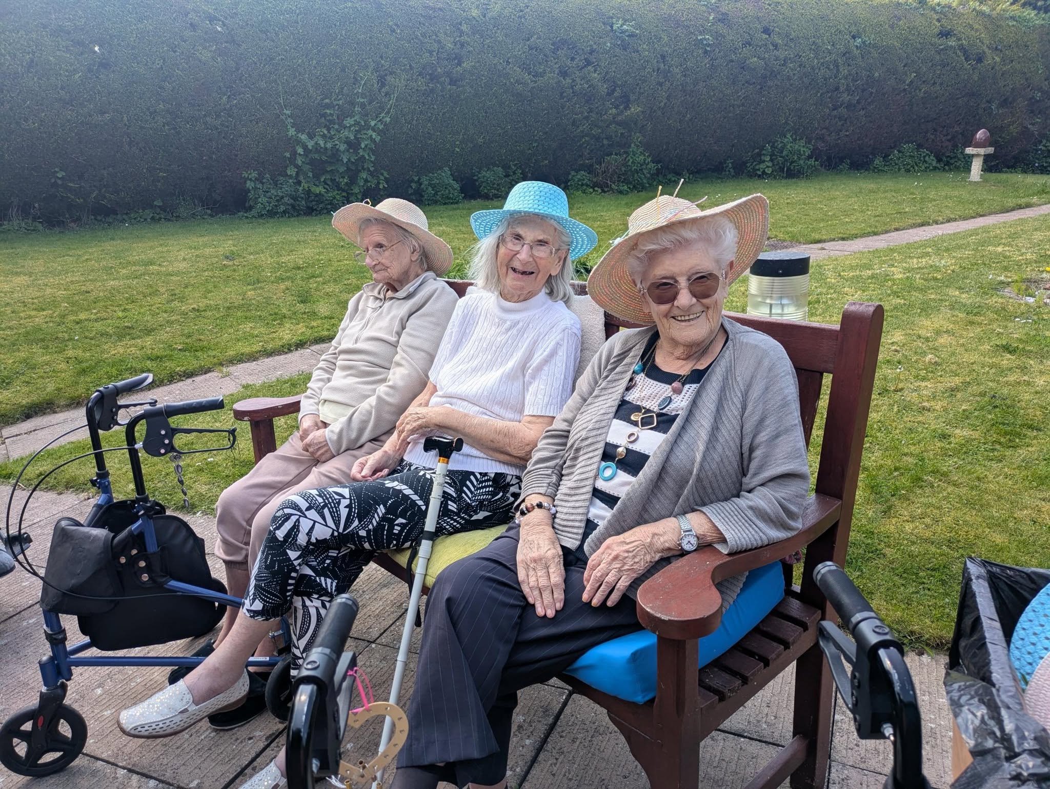 Phil Mead House residents sitting on bench, enjoying the outdoor celebrations