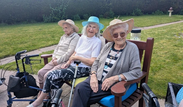 Phil Mead House residents sitting on bench, enjoying the outdoor celebrations