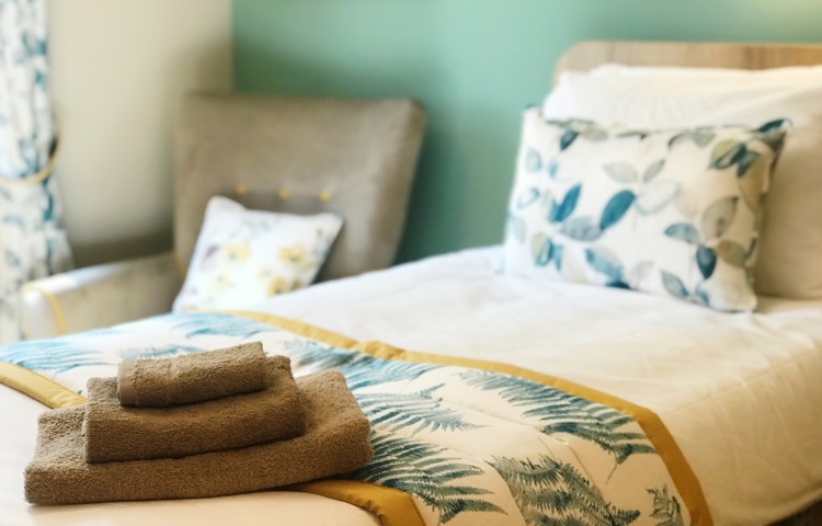 A beautifully styled resident room at Westall House dementia care home in Horsted Keynes with fresh towels and decorative pillows