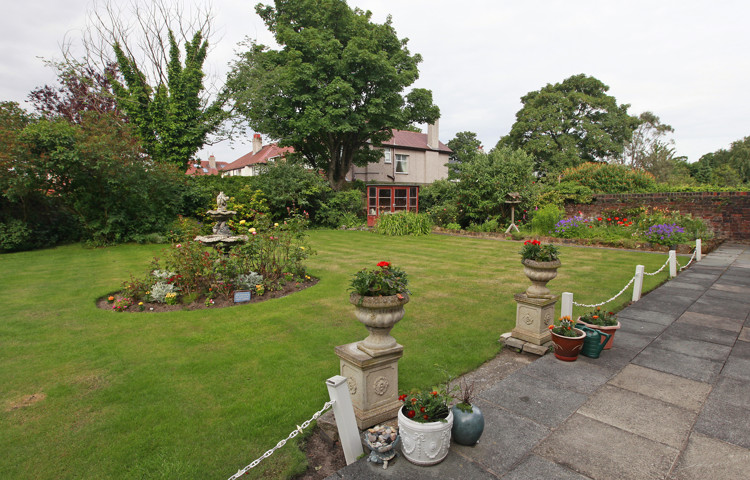 A large garden with stone pillars and flowers
