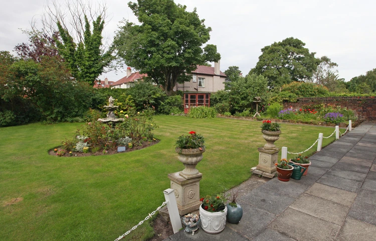 A large garden with stone pillars and flowers