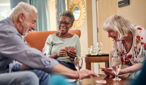Group Of Older People Sitting Round A Table Playing Cards