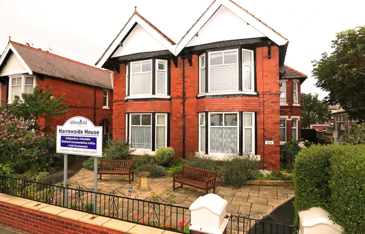 Large red brick house with two benches at the front