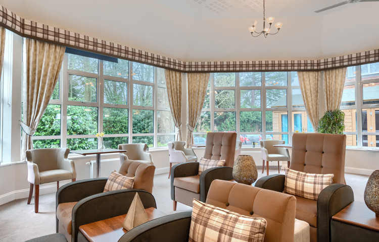 Spacious and bright sitting room at Westall House Residential Care Home in Horsted Keynes with comfortable armchairs and large windows overlooking gardens