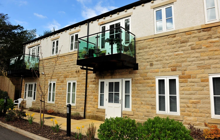 External view of Woodlands a stone house with glass balcony