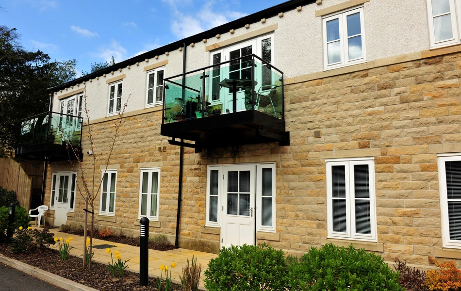 External view of Woodlands a stone house with glass balcony