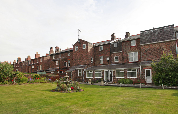 Large red brick house with garden and bird bath
