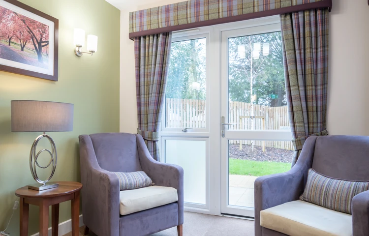 A cosy sitting area at Westall House with comfortable armchairs and a garden view