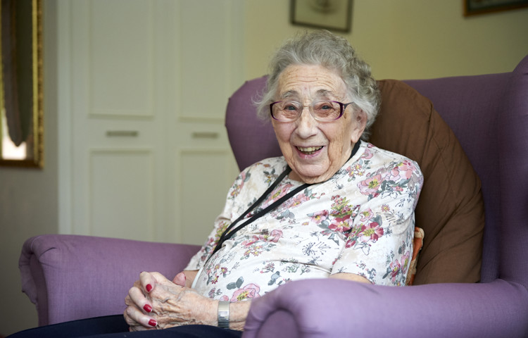Smiling, happy resident sitting in armchair