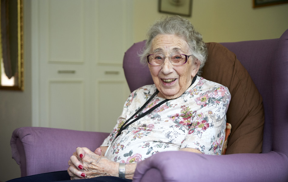 Smiling, happy resident sitting in armchair