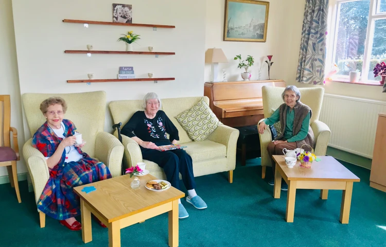 Residents enjoying tea and biscuits in the lounge