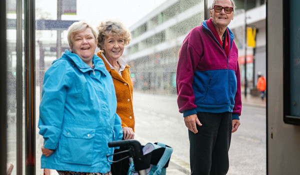 Smiling Older People At A Bus Stop