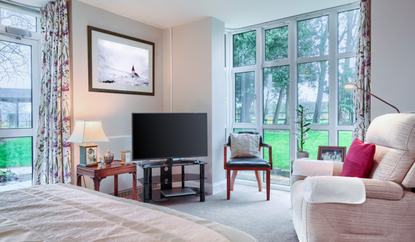 Comfortable armchair and television in a resident's room at Westall House Residential Care Home, Horsted Keynes, creating a relaxing and private space