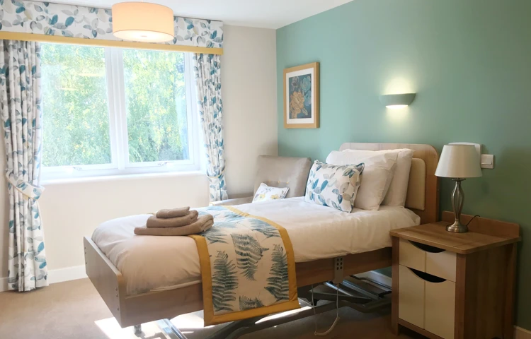 Bright, beautiful resident room at Westall House with mint green walls, floral curtains, and a patterned throw