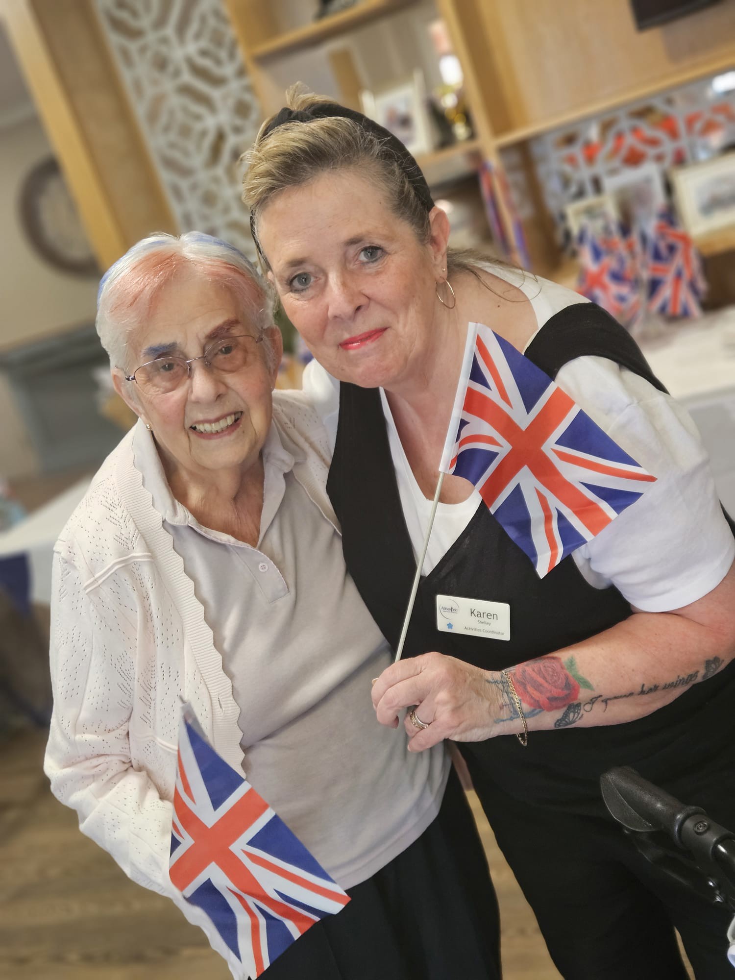 Resident and staff member at Speedwell Court holding their Union Jack flags
