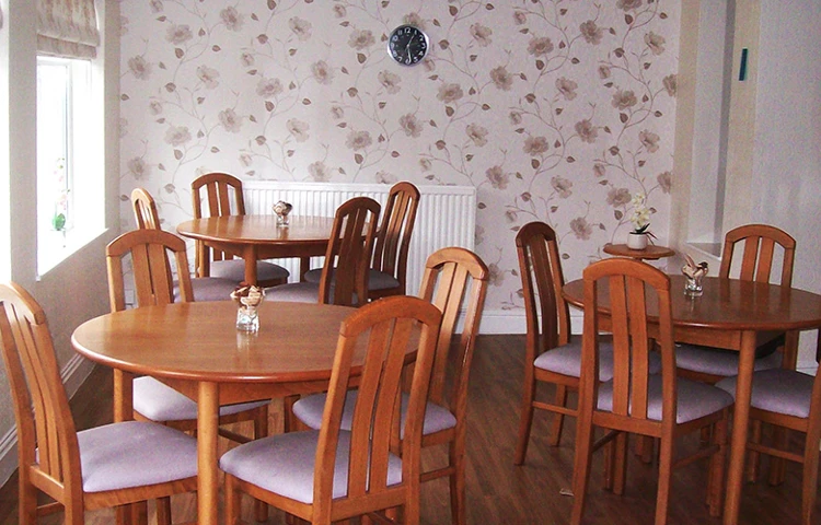 Dining area with tables and chairs and flowered wallpaper