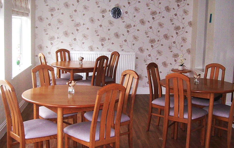 Dining area with tables and chairs and flowered wallpaper