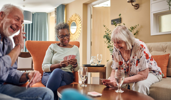 Group Of Older People Sitting Together Playing Cards