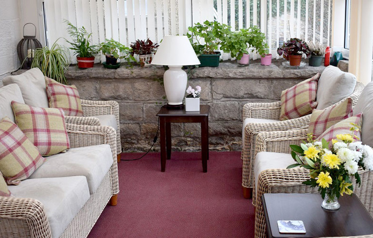 The conservatory area with a sofa and chairs