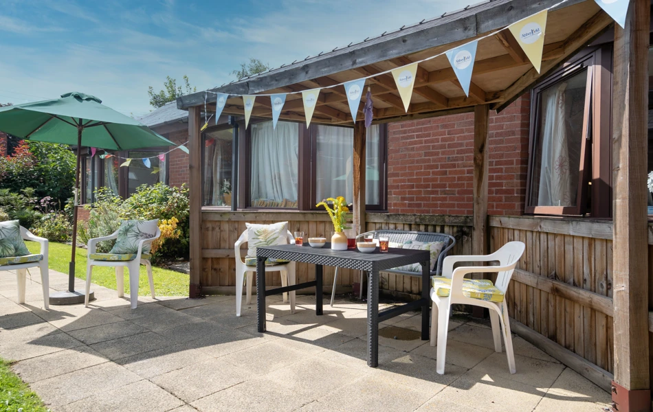 View of garden seating area with a pergola to relax under.