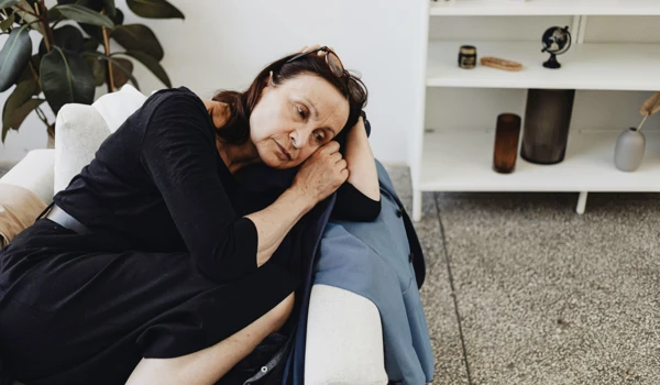 Older Woman Curled Up In Armchair