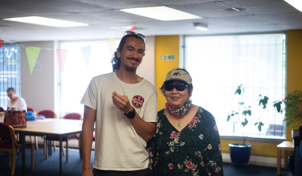 Man And Older Woman Standing Next To Each Other In Building