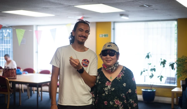 Man And Older Woman Standing Next To Each Other In Building