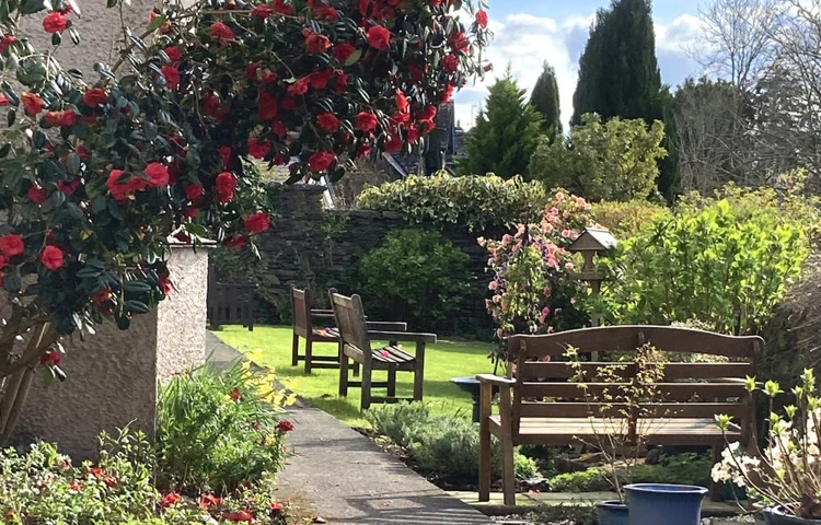 Welcoming Garden Seating Areas in full bloom at Abbeyfield Nine Oaks in Windermere, LA23 1BB