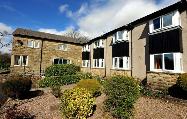 Garden area with shrubs under the house windows outside Abbeyfield House, Settle
