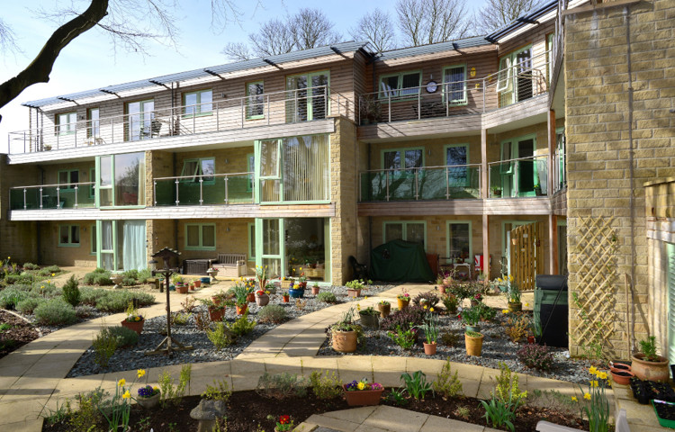 Outside garden area with bird table and colourful plants at Ing Royde,