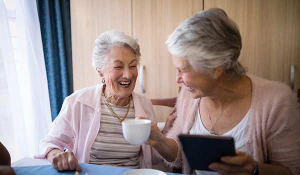 Two Smiling Older Women Enjoying A Game Of Chess And A Tea