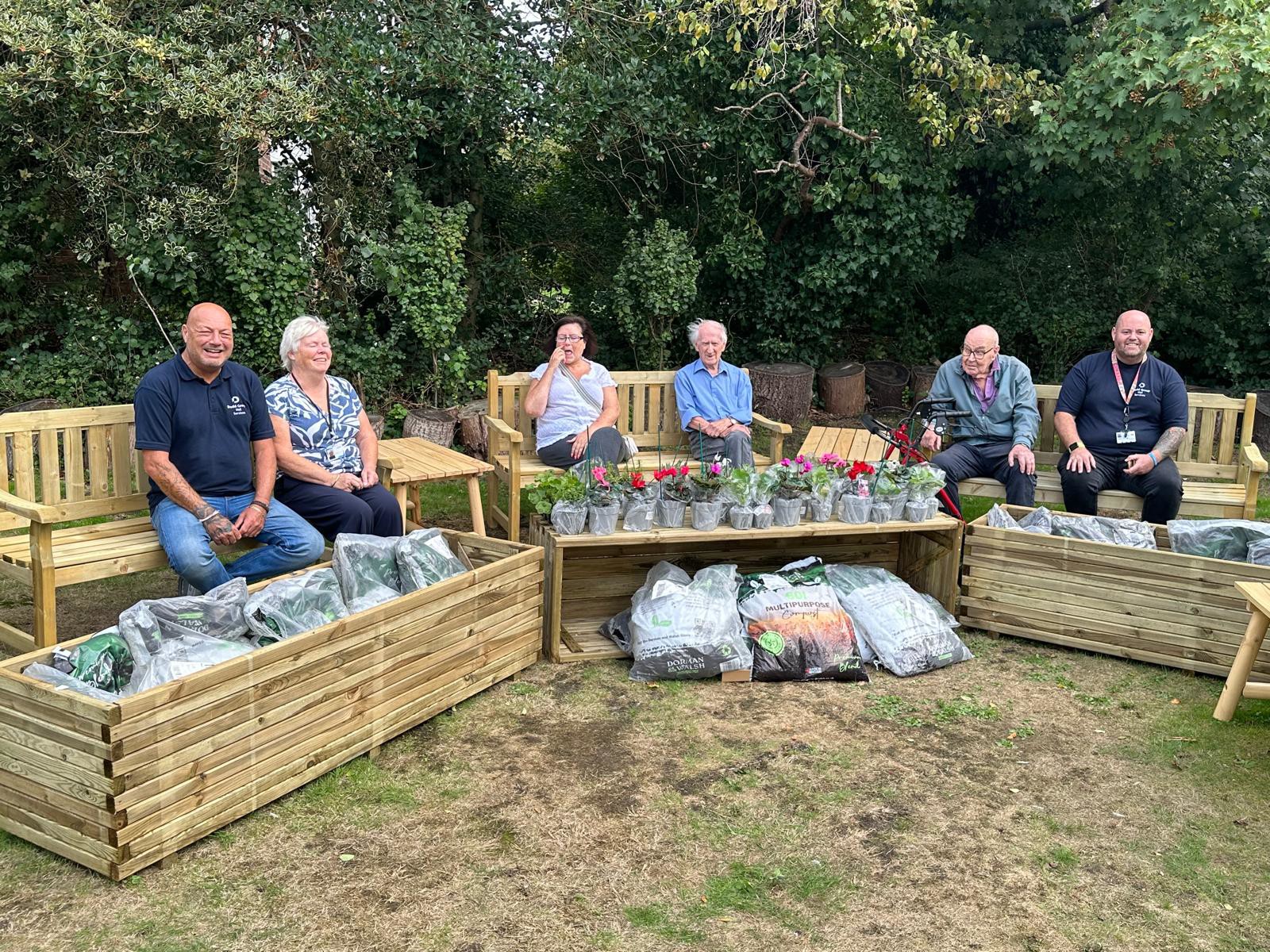 Dodd Group Volunteers sitting with residents in the garden